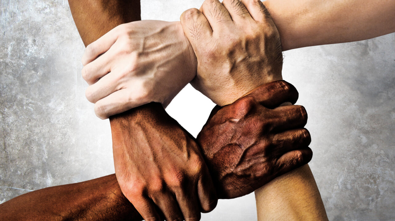 multiracial group with black african American Caucasian and Asian hands holding each other wrist in tolerance unity love and anti racism concept isolated on grunge background